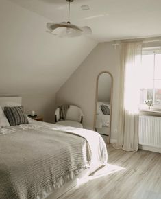 a bedroom with white walls and wooden floors