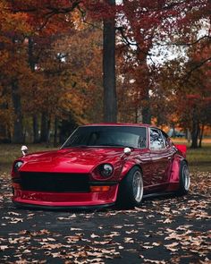 a red sports car parked in the leaves