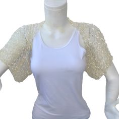 a mannequin wearing a white tank top with gold sequins