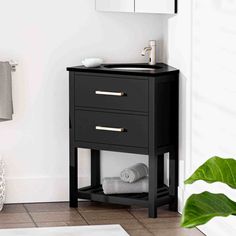 a bathroom with a sink and mirror next to a plant on the floor in front of it