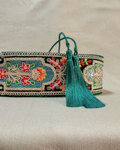 an embroidered bag with tassels and flowers on it