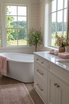 a white bath tub sitting in a bathroom next to a window with lots of windows