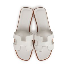 This pair of Oran Sandals are in white box leather with contrast stitching and feature the iconic H crossover strap. Origin: ItalyCondition: New and never wornAccompanied by: Hermes box, dustbags, carebook and ribbonSize: 37 EU White Hermes Oran, White Hermes Sandals, Hermes Slides, Hermes Sandals, Hermes Oran Sandals, Hermes Birkin 25, Hermes Shoes, Girl Closet, Hermes Oran