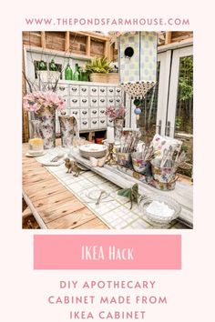 a table with flowers and vases on it in front of a kitchen area that is made from ikea cabinets