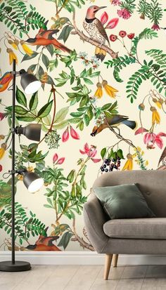 a living room with a couch, lamp and wallpaper that has birds on it