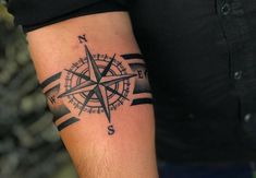 a man with a compass tattoo on his arm