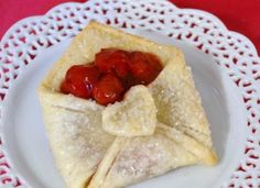 a white plate topped with crepes covered in jelly and toppings on top of it