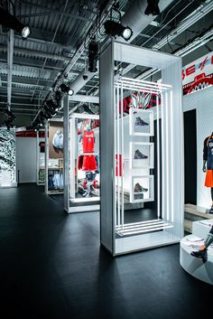 a man standing in front of a display case filled with sports gear and shoes on mannequins