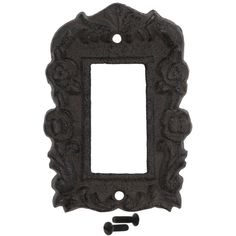 an ornate cast iron light switch plate cover with screws on the side and two holes in the middle