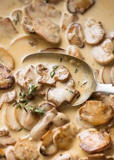 a spoon full of mushroom soup with mushrooms on the side