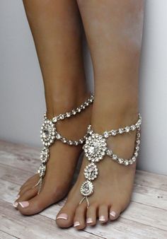 Katy Barefoot Sandals can only be described in one word: exquisite. This stunning foot jewelry features over 200 individual rhinestones which vary in size and adorn this pair. Handmade using silver shade, Katy Sandals are also available in gold and rose gold. The centerpieces are carefully connected together, while rhinestone embedded Kundan chain runs along the side of the sandals. The back of the sandals feature comfortable lobster clasp and an adjustable 2 inch closure. Wear these gorgeous sa Elegant Crystal Sandals For Wedding, Elegant Crystal Wedding Sandals, Elegant Barefoot Sandals For Party, Crystal Open Toe Sandals For Wedding, Elegant Silver Sandals With Crystal, Elegant Silver Toe Ring Barefoot Sandals, Elegant Silver Anklets For The Beach, Elegant Crystal Sandals With Bling, Elegant Bling Anklets For Party