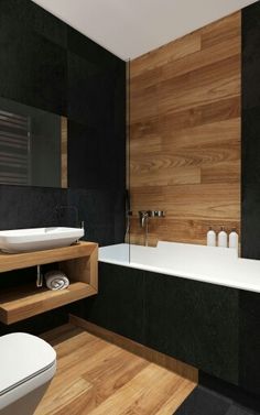 a white sink sitting next to a bath tub in a bathroom on top of a wooden shelf