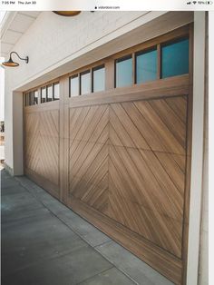 a wooden garage door with windows on the side of it and a light hanging from the ceiling