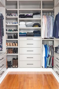 a walk in closet filled with lots of drawers and shirts on top of wooden floors