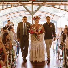 a man and woman are walking down the aisle