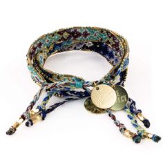 the multicolored bracelet with gold charm is shown on a white background and has two different