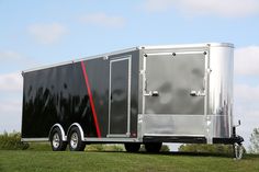 a large trailer parked on top of a lush green field