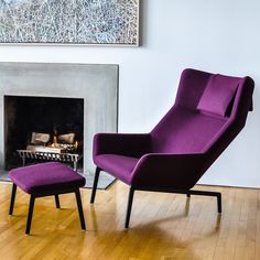 a purple chair and footstool in front of a fireplace