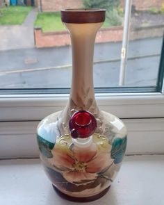 a glass vase sitting on top of a window sill