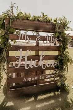 a wooden sign with greenery on it