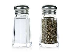 two salt and pepper shakers sitting next to each other