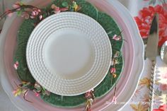 the plates are decorated with pink and green flowers on them, along with silverware