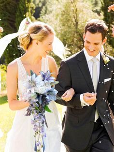 a bride and groom walking through confetti thrown in the air