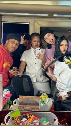 four people posing for a photo in front of a table full of food