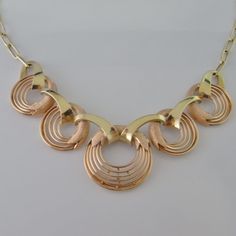 A fine hand made 1940s high art deco necklace in rose and yellow gold. This divine necklace features a central hand made focus that is hand crafted in rose and yellow gold. The design is exceptionally streamlined. The necklace measures 17" long and is 13/16" wide (432mm x 20mm). Made from fine 14K rose and yellow gold it weighs a total of 23.19 grams. It is in excellent condition.This is a one of a kind original art deco necklace not a reproduction item in the deco style. An appraisal shall acco Rose Gold Collectible Necklaces, Collectible Rose Gold Necklaces, Victorian 14k Rose Gold Necklace, Antique Necklace With Polished Finish For Anniversary, Antique Necklaces With Polished Finish For Anniversary, Antique Polished Finish Necklace For Anniversary, Gold Elegant Collectible Necklace, Retro Yellow Gold Round Jewelry, Art Deco Yellow Gold Necklace For Formal Occasions