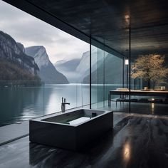 a large bath tub sitting in the middle of a room next to a lake and mountains