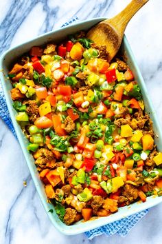 a casserole dish filled with ground beef and vegetables