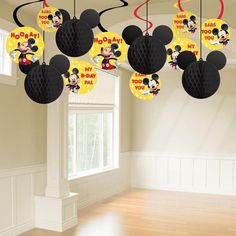 mickey mouse decorations hanging from the ceiling in a room with hard wood floors and white walls