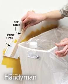 a person is painting the wall with yellow paint