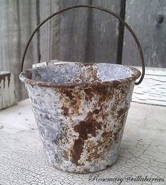 an old rusty bucket sitting on top of a table