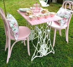 a pink table and chairs in the grass