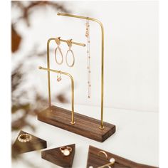 three pairs of earrings on wooden stand with white background