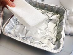 someone is cleaning the foil pan with a cloth on it and a napkin in their hand