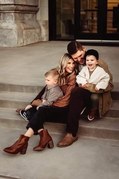 a man, woman and two boys sitting on steps with their arms around each other