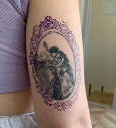 a woman's arm with a tattoo on it that has an image of two people hugging