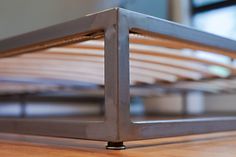 a metal bed frame on top of a wooden floor