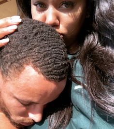 a man and woman are looking at each other while they both have braids on their hair