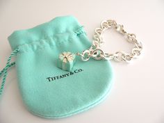 Overview: Here is a gift that she will surely adore! It is shiny, stylish, and super versatile! This piece will make someone REALLY happy! :) Offered for sale is a wonderful Tiffany & Co. Sterling Silver and Blue Enamel Signature Gift Box Bracelet. Hanging from its bright Tiffany silver chain is a very pretty Turquoise Gift Box charm! A classic Tiffany piece that any girl will adore! The Gift Box charm hangs from its Sterling Silver Tiffany clasp - it is removable from the bracelet and thus Elegant Jewelry Gift Ready For Birthday, Elegant Birthday Gift Jewelry, Gift Ready, Elegant Birthday Gift-ready Jewelry, Elegant Jewelry For Birthday Gift, Rectangular Bracelet With Box Clasp For Gift, Rectangular Bracelet With Box Clasp As Gift, Luxury Jewelry Gift With Original Box, Luxury Jewelry Gift In Original Box, Designer Rectangular Bracelets As Gift