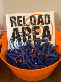 a bucket filled with blue crayons next to a sign that reads reload area