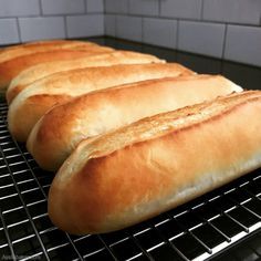 four loaves of bread cooling on a rack