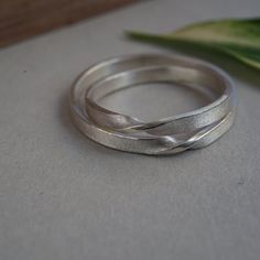 La banda de Mobius es un anillo delgado de aproximadamente 2 mm de ancho, por 0,9 mm de espesor, y esta hecho a mano por mí, uno por uno en su talla.  Este listado es para dos anillos de banda de Moebius en plata, si buscas este anillo en oro los tienes aquí: Una banda de Möbius es una construcción matemática, esta es una mezcla entre el infinito y la banda de Moebius, una representación de lo eterno con un toque diferente. // Todas mis piezas están diseñadas y fabricadas a mano en mi taller // Mobius Infinity, Mobius Wedding Band With Engagement Ring, Matching Rings For Couples, Mobius Ring Wedding, Mobius Rings, Mobius Strip Wedding Ring, Mobius Jewelry, Mobius Ring, Slim Ring