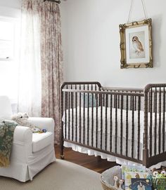 a baby's room with a crib, chair and pictures on the wall