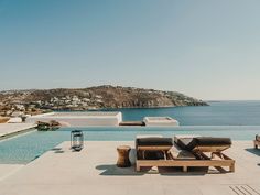 an outdoor lounge area next to a swimming pool