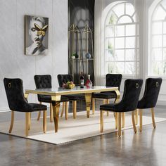 a dining room table with black chairs and a white rug on the floor in front of it