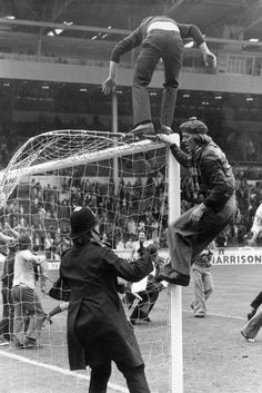 an old black and white photo of men playing soccer