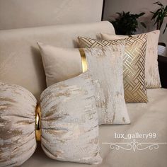 four pillows on a couch with gold trim